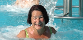 Badegast an der Nackendusche im großen Außenbecken Thermalbereich Badegast an der Nackendusche im großen Außenbecken Thermalbereich